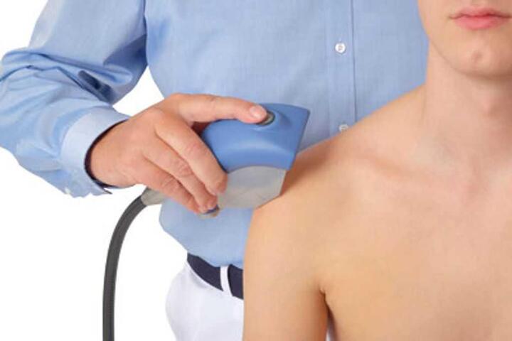 shockwave-therapy image image of male physiotherapist doing dry puncture on the back of patient in clinic